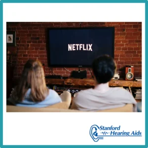 A couple looks at a screen that says, "Netflix." 