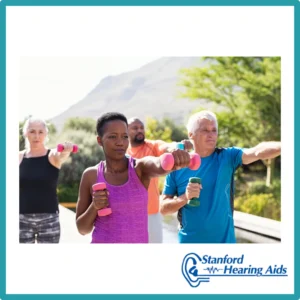 Older people lift weights outside. 
