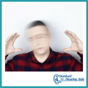 A man's head is blurry as he holds his hands up to it.