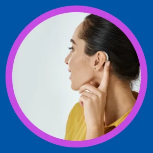 A woman touches her hearing aid.