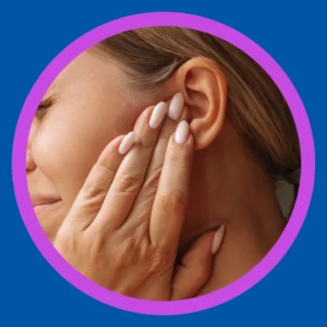 A woman holds her ear and grimaces. 