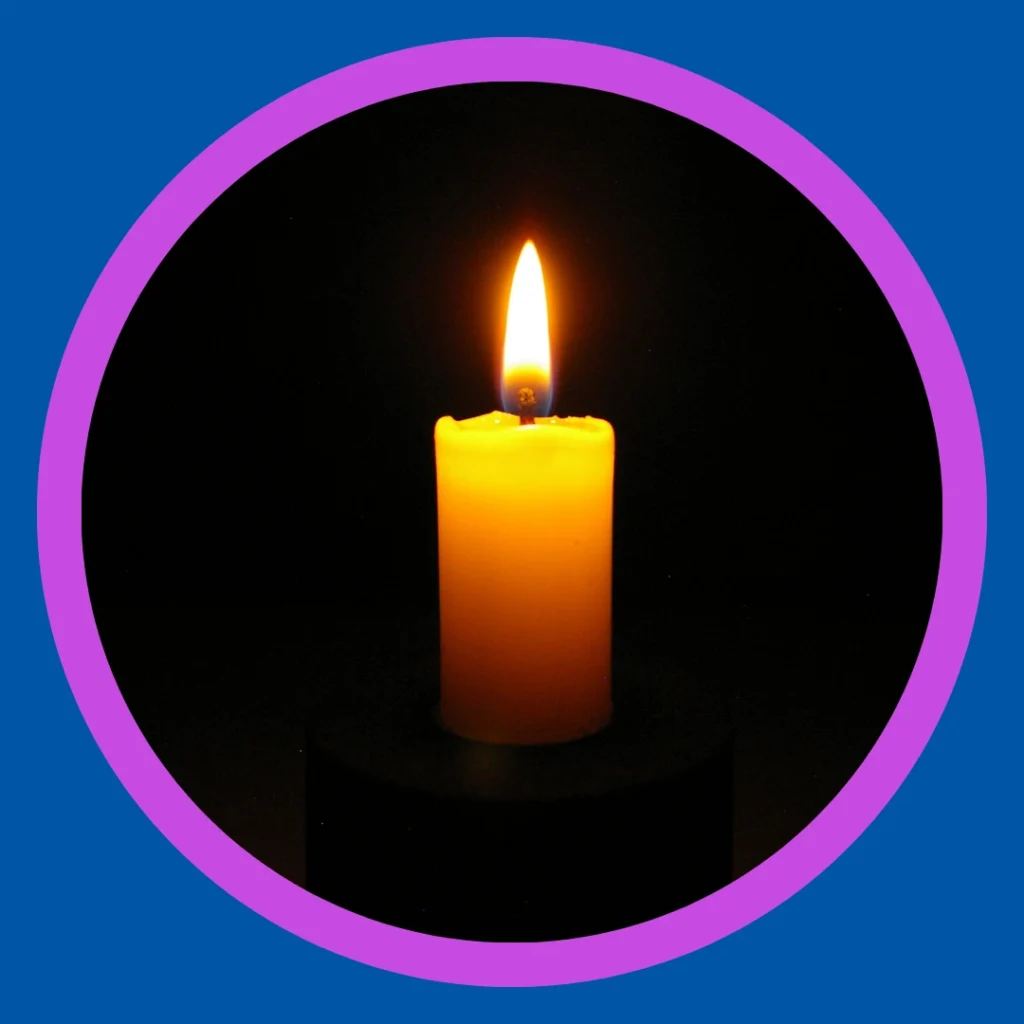 A lit candle stands against a black background.