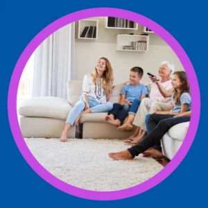 Grandma watches TV with her grandchildren. 