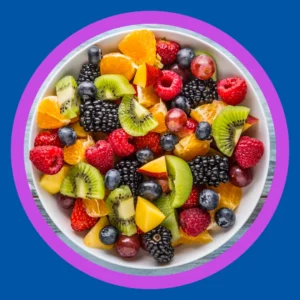 A plate of fruits including berries and kiwi sits on a table. 