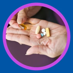 A hand holds a bunch of pills. 