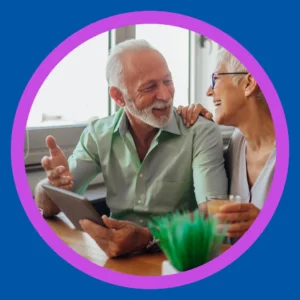 A smiling couple looks at a phone. 