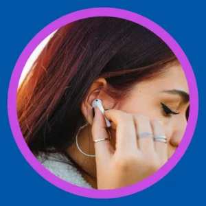 A young woman puts an ear bud in. 