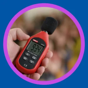 A hand holds a decibel meter. 
