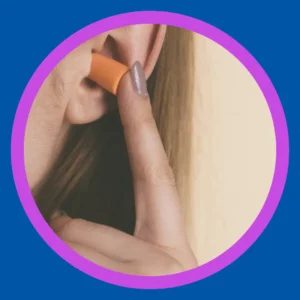 A woman puts an ear plug in. 