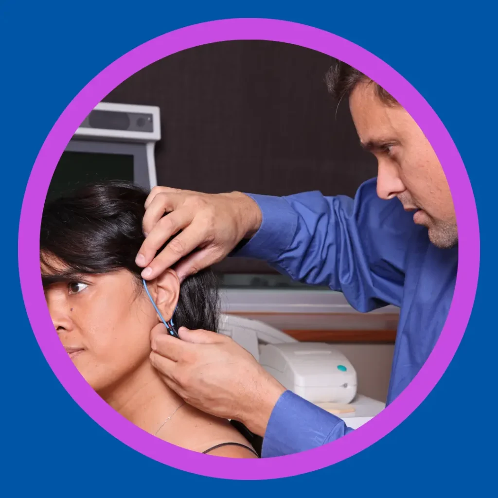 An audiologist measures a hearing aid on a patient.