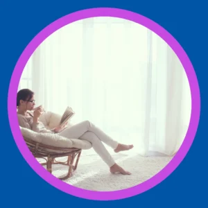 A woman relaxes and reads in the sunlight. 