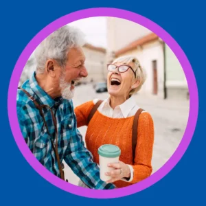 An older man and woman laugh together.