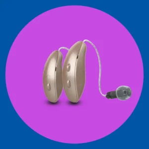 A gold Starkey Edge AI hearing aid stands on  purple background. 