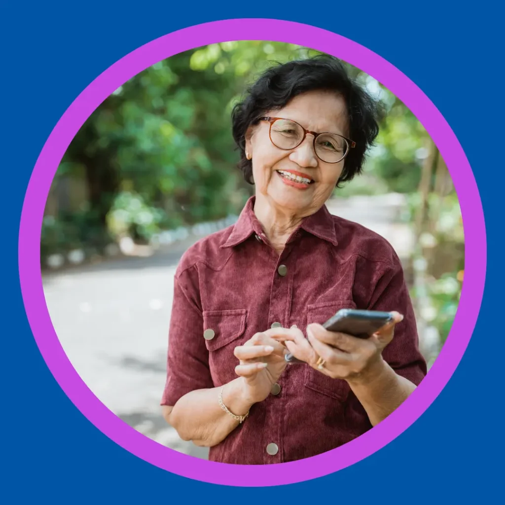 A smiling woman holds her phone.