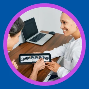 An audiologist shows a tray of hearing aids to a patient. 