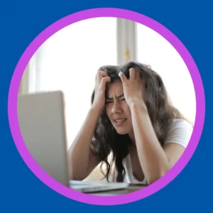 A woman looks frustrated at her laptop. 