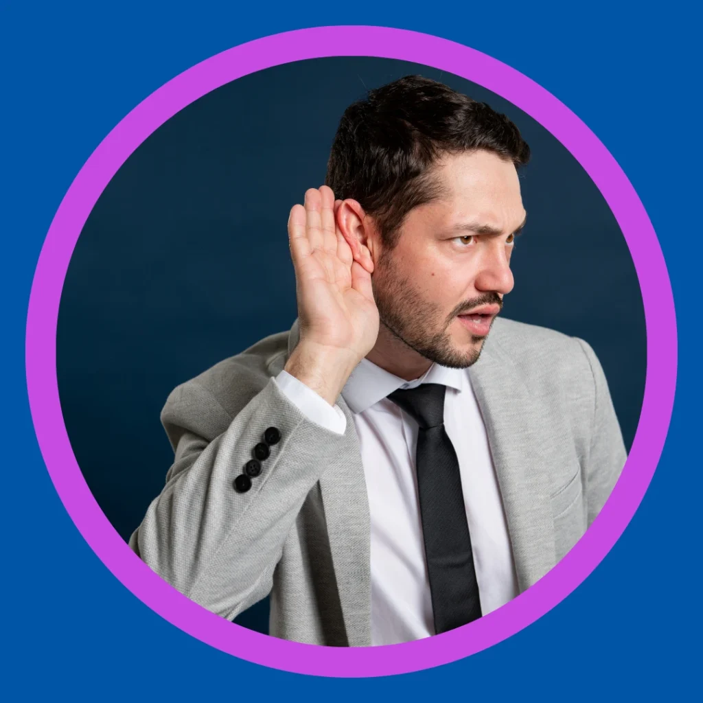 A man his hand by his ear to hear better.