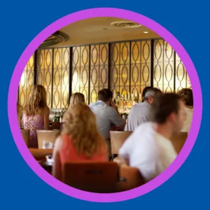 People sit in a crowded restaurant. 