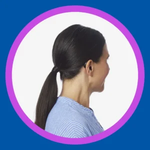 A woman faces away to show her small black hearing aid.