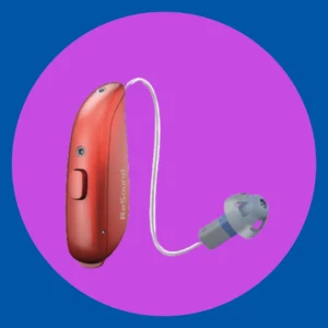 A red microRIE hearing aid stands on a purple hearing aid. 