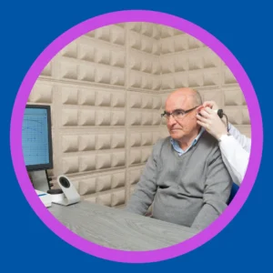 An audiologist examines an older man's ear. 