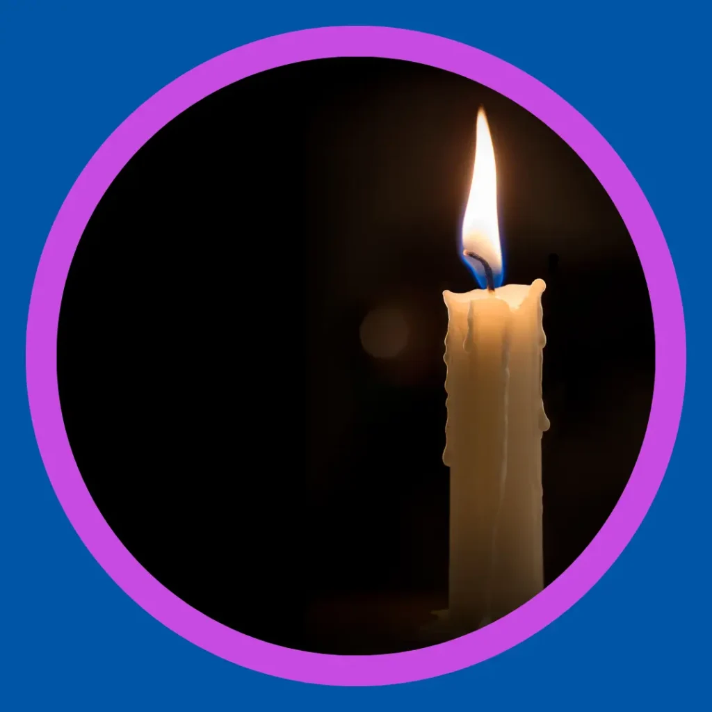 A lit candle stands against a black background.