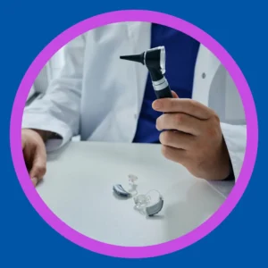 An audiologist holds an otoscope over a table. 
