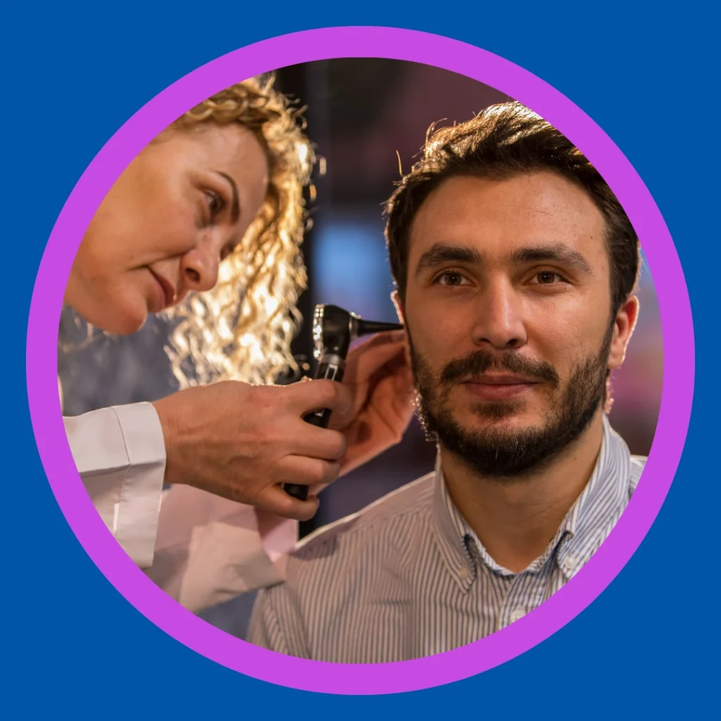 An audiologist looks in a patient's ear.