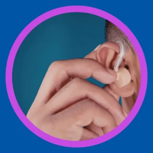 Someone puts a hearing aid into their ear. 