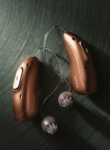 A pair of Phonak EON hearing aids sit on a table.